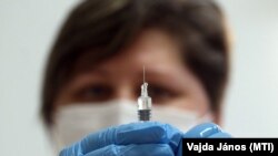 Лікарка готується зробити антиковідне щеплення пацієнту в Угорщині (ілюстраційне фото)