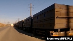 Колонна грузовиков-зерновозов на объездной дороге после ночной атаки на порт Феодосии, Крым, Украина, 27 декабря 2023 года