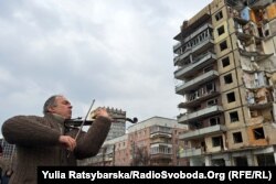 У Дніпрі на місці ракетного удару по багатоповерхівці на житловому масиві Перемога під час вшанування пам'яті 46 загиблих мешканців. Лютий 2023 року