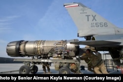 Ооганстандагы Баграм аэродромундагы жерде иштеген кызматкерлер F-16дан кыймылдаткычты чыгарып жатышат, 2014-жыл