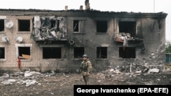 Український поліцейський біля пошкодженої обстрілом будівлі у Вовчанську, 13 травня 2024 року