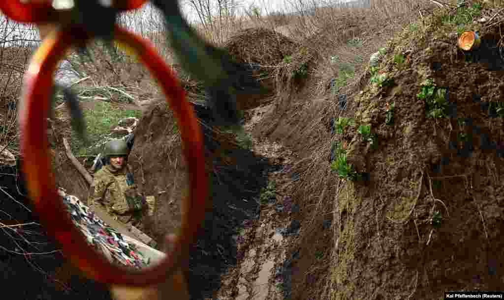 Боєць в окопі. Його бачить побратим у дзеркалі під час ранкових гігієнічних процедур. 