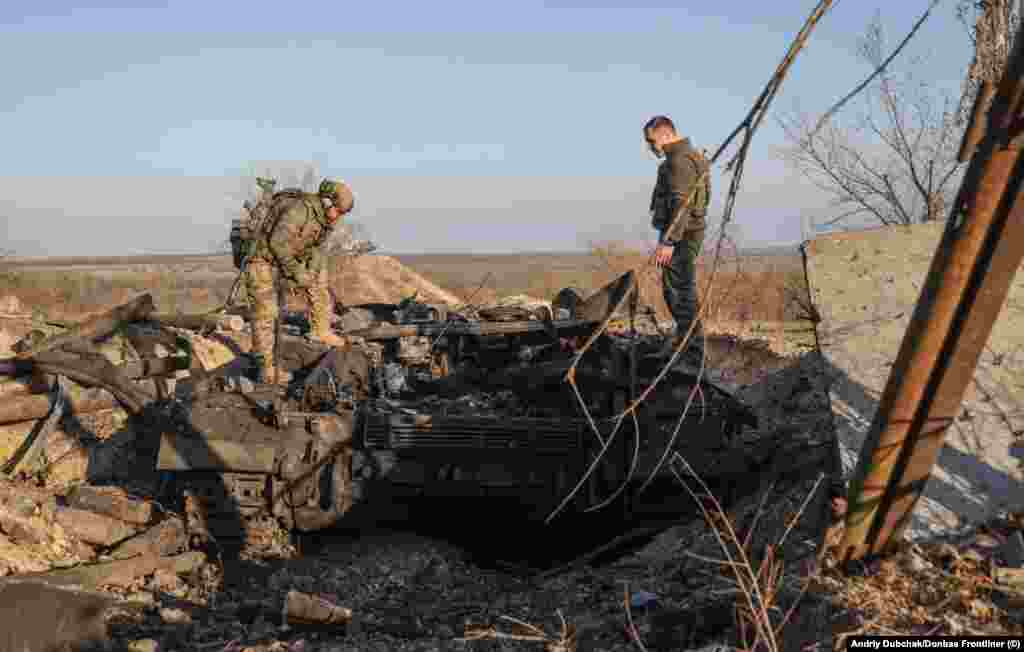 Украина әскерилері қираған танкіні тексеріп жүр. 