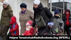 Українські жінки з дітьми переходять через пункт пропуску Шегині із України у Польщу. 8 березня 2022 року