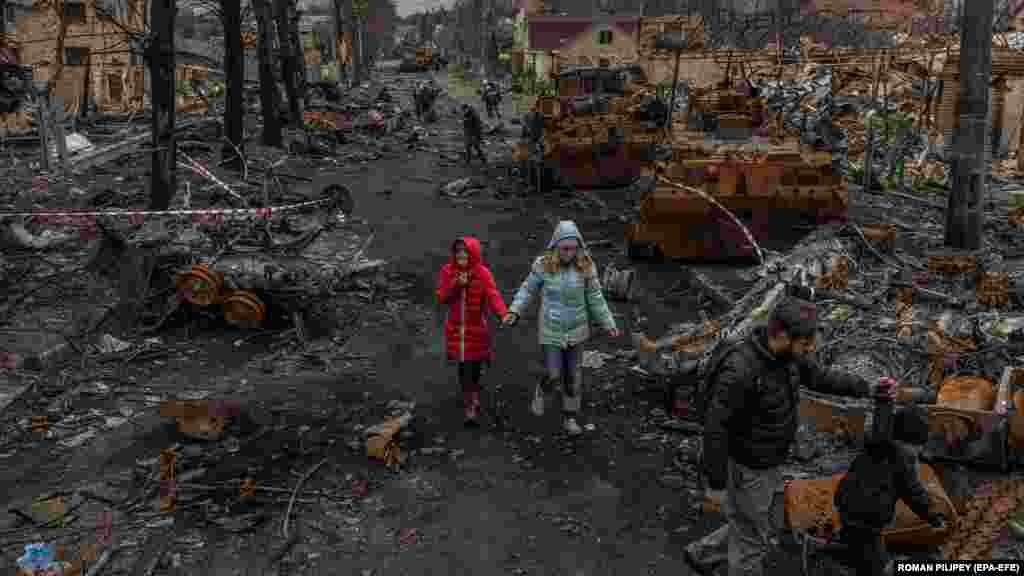 Украинаның Буча шәһәрендә яшәүче Владислава Любарец (уртада) гаиләсе белән Русиянең тар-мар ителгән хәрби техникасы яныннан уза. 6 апрель 2022 ел. (EPA-EFE/ROMAN PILIPEY). 2022 елның 24 февралендә Русия гаскәрләре Украинага бәреп керде, бу илдә меңнәрчә үлемнәргә, җимерелүләргә китерде. Русия гаскәрләре чигенгәннән соң Киев өлкәсенең Буча шәһәрендә һәм башка өлешләрендә газапланып үтерелгән йөзләрчә сивил кеше табылган. Буча урамнарында таралып яткан мәетләр күренешләре безнең фотогалереяда.