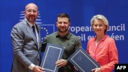 Президент Європейської ради Шарль Мішель (ліворуч), президент України Зеленський (у центрі) і президентка Європейської комісії Урсула фон дер Ляєн під час церемонії підписання угоди про безпеку в штаб-квартирі ЄС у Брюсселі, 27 червня 2024 року