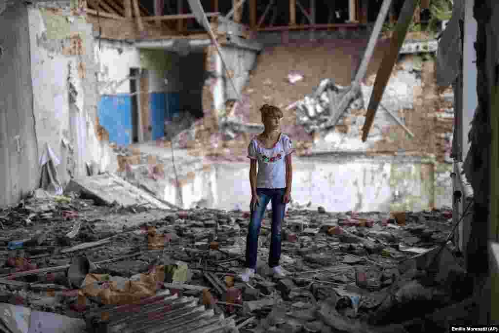 12-летняя София Клишня стоит среди обломков своего бывшего класса, на том самом месте, где когда-то стояла ее парта. «Страшно стоять в разрушенной части класса, где я когда-то училась», – отмечает София