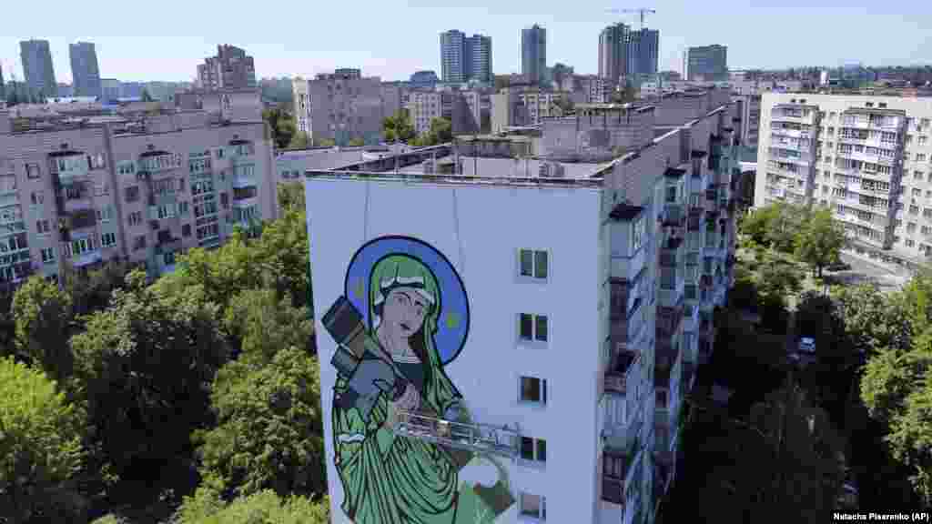 Художники довершують мурал під назвою «Святий Джавелін» – Діва Марія, яка тримає протитанкову ракету. Київ, 24 травня 2022 року
