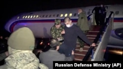 ARMENIA -- A freed Armenian captive is escorted off a Russian military plane upon arrival at a military airport outside Yerevan, December 14, 2020