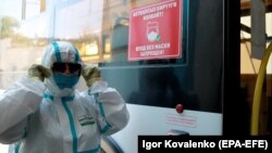 Сотрудник троллейбусной автотранспортной компании распыляет дезинфицирующее средство внутри троллейбуса в Бишкеке. 14 июня 2021 года. 