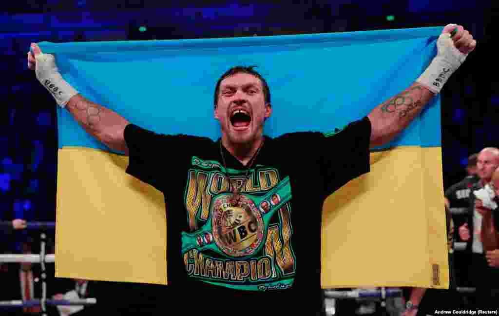 Український боксер Олександр Усик з українським прапором після перемоги нокаутом над британцем Тоні Белью. Українець захистив звання абсолютного чемпіона світу у ваговій категорії до 90,7 кілограма. Велика Британія, Манчестер, 10 листопада 2018 року БІЛЬШЕ ПРО ЦЕ