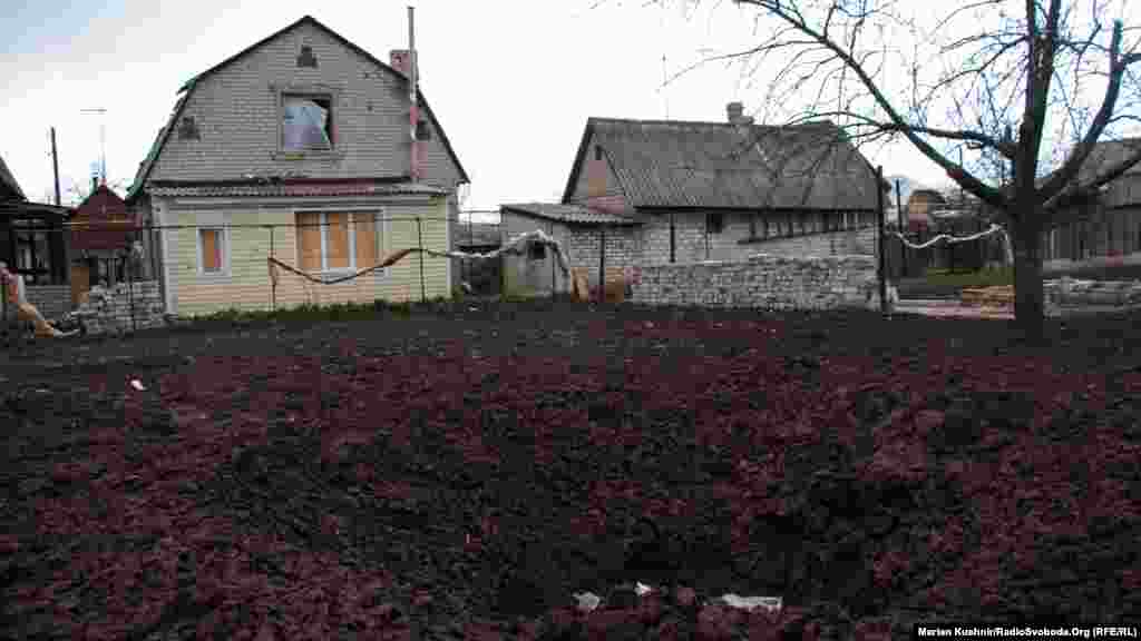 Типовий зараз для села краєвид. Яма на фотографії – наслідок потрапляння у город 152 мм снаряда від САУ (самохідна артелирійська установка), використання якої заборонено Мінськими домовленостями
