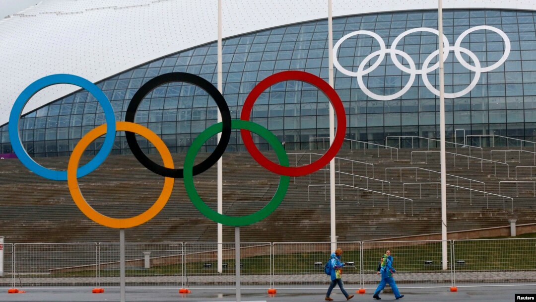 Volonteri prolaze pored olimpijskih krugova ispred ledene dvorane u Olimpijskom parku u Sočiju