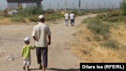 Жители села Достык идут вдоль границы Казахстана с Узбекистаном. Южно-Казахстанская область, 18 июня 2017 года.