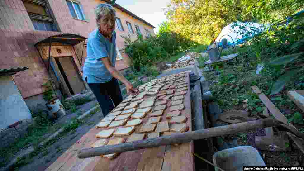 Місцева жителька Ольга сушить на сухарі хліб, який їй дали військові. – Чому звідси не їдете? – Куди? У мене пенсія – 1400 (гривень). Яке житло я можу знайти за ці гроші? А ще треба прожити. І комунальні
