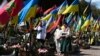 У велікодную нядзелю сям'я моліцца перад магілай загінулага ўкраінскага салдата на вайсковых могілках у Львове