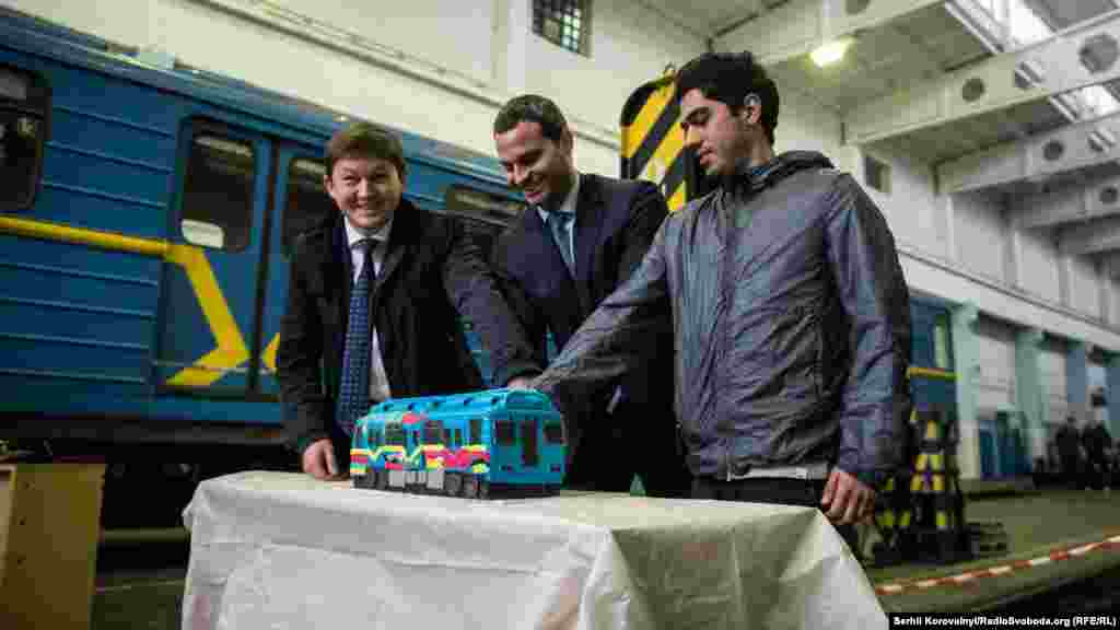 Заступник голови КМДА Ілля Сагайдак, директор КП «Київський метрополітен» Віктор Брагінський та іспанський художник Кенор розрізають торт у вигляді рофарбованого вагону метро