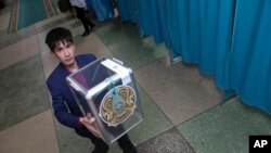 ОСК қызметкері парезидент сайлауы өтетін күні бюллетень салатын жәшікті әкеле жатыр. Нұр-Сұлтан, 9 маусым 2019 жыл.