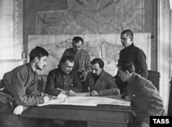 Військові командири більшовиків «обговорюють придушення Кронштадтського повстання». На задньому плані – мапа острівної фортеці