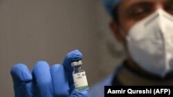 Медработник показывает ампулу с китайской вакциной Sinopharm.