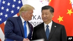 Президент США Дональд Трамп (ліворуч) тисне руку президенту Китаю Сі Цзіньпіну під час зустрічі на полях саміту «Великої двадцятки» в Осаці, на заході Японії. 29 червня 2019 року 