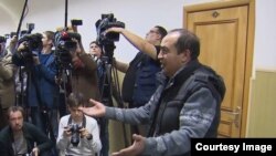 Ахрол Азимов уулдарынын сотунда журналисттерге интервью берүүдө.
