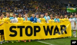 Гравці тримають банер із закликом зупинити війну
