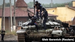 Українські поліцейські роблять селфі на підбитому під час контрнаступу ЗСУ російському танку в місті Ізюмі, 14 вересня 2022 року