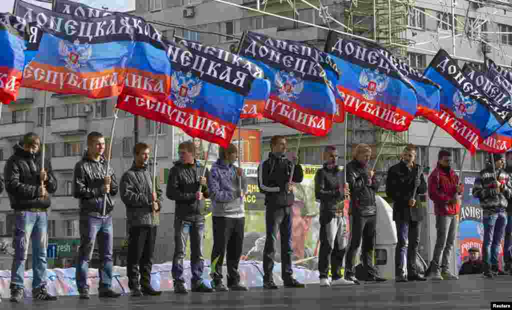 Мужчины с флагом самопровозглашенной Донецкой народной республики стоят в центре Донецка. 19 октября 2014 года.
