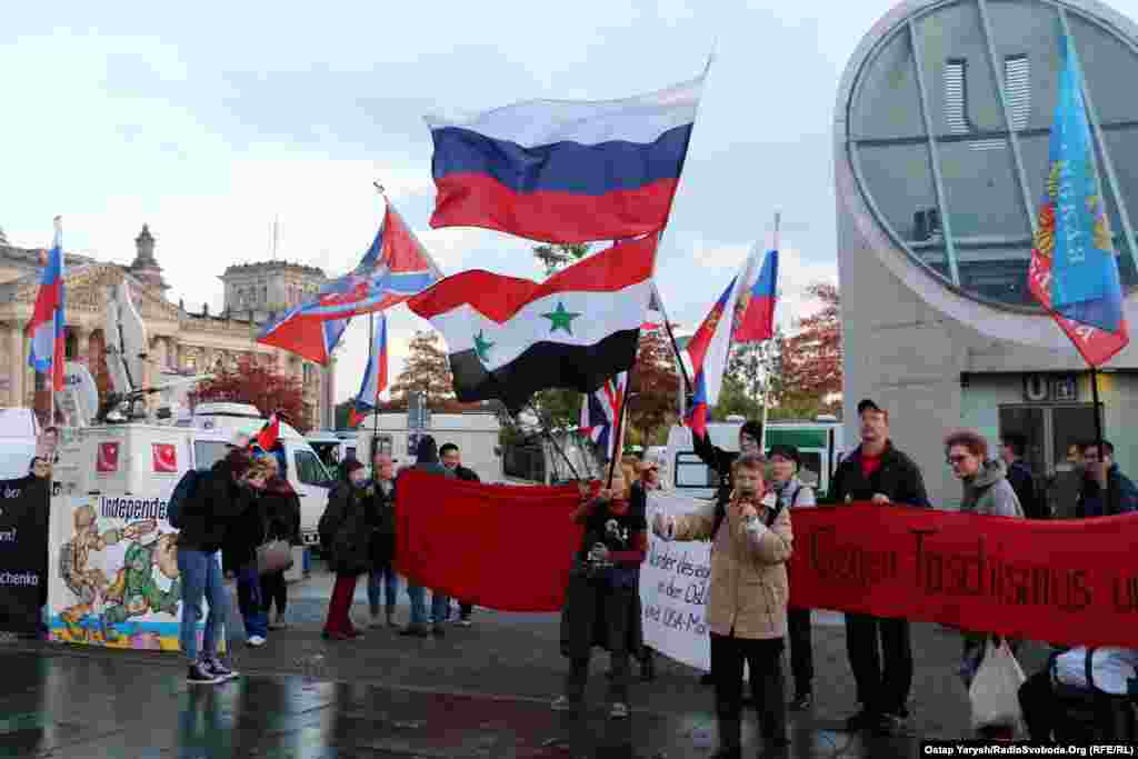 На акции развеваются флаги России, Советского Союза, а также так называемой «Новороссии» и группировок «ДНР» и «ЛНР», которые признаны в Украине террористическими